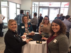 Four smiling women holding wine glassses